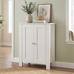 White wooden cabinet with double doors, set against a light green wall in a hallway