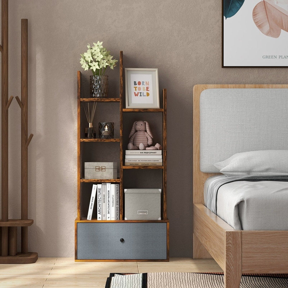 A rustic brown wooden bookcase with a grey fabric drawer, placed next to a bed in a bedroom