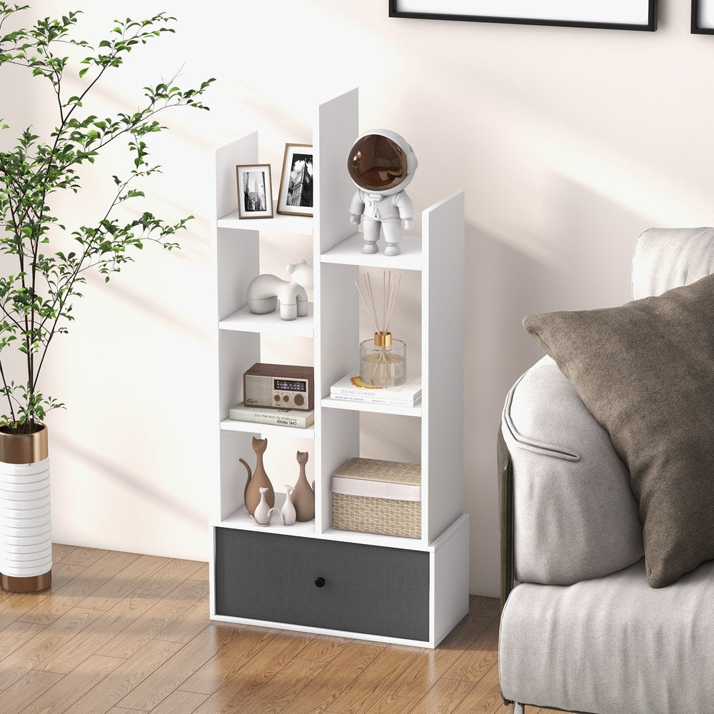 The white wooden bookcase with a grey fabric drawer is shown in a modern living room next to a sofa