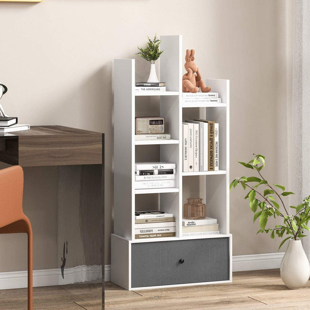 The white wooden bookcase with a grey drawer is placed next to a desk in a home study