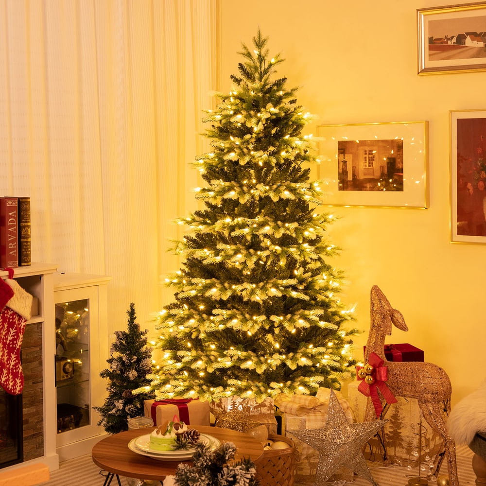 The Christmas tree is set up and decorated in a cosy living room with presents underneath