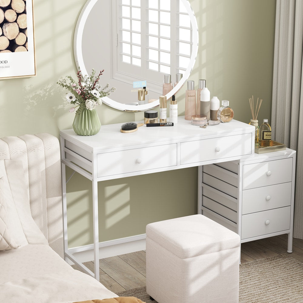 The office desk styled as a dressing table with a mirror and beauty products