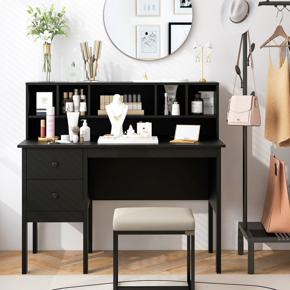 The office desk is set up as a dressing table with makeup and jewellery, with a stool and a mirror