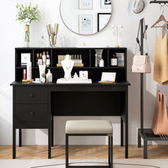 The office desk is set up as a dressing table with makeup and jewellery, with a stool and a mirror