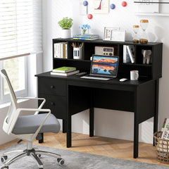 The office desk is set up for work with a laptop, books and a plant, in a room with a chair
