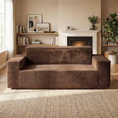 The brown corduroy sofa positioned in a cosy living room with a fireplace