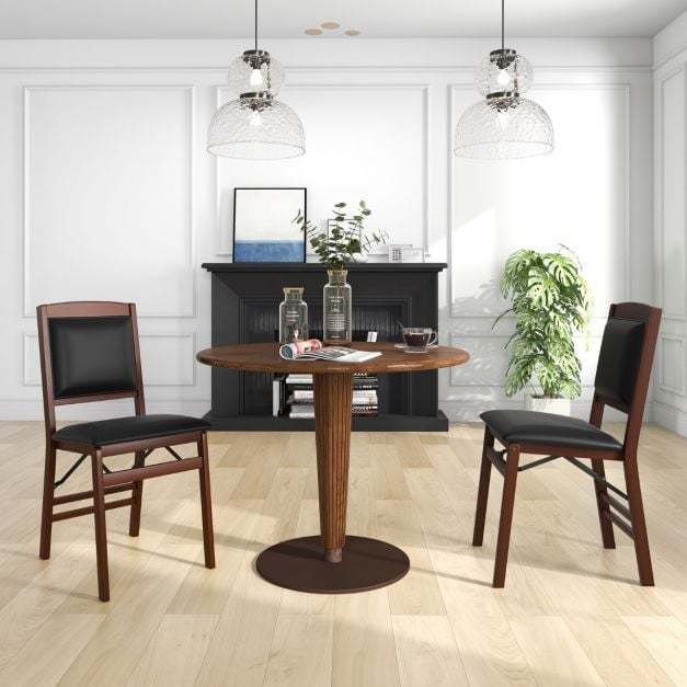 Two dining chairs with padded seats and soft backrests beside a round table in a dining room