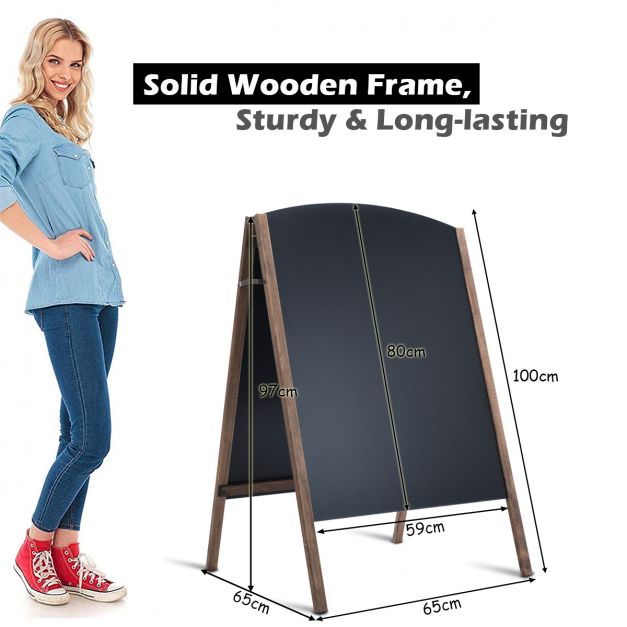 A woman stands next to a double sided A frame chalkboard sign with dimensions shown