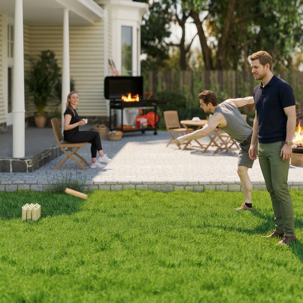 Three adults playing the wooden scatter game on a sunny lawn with a barbecue in the background