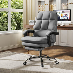 Grey office chair with footrest set up in a home office with a computer and window