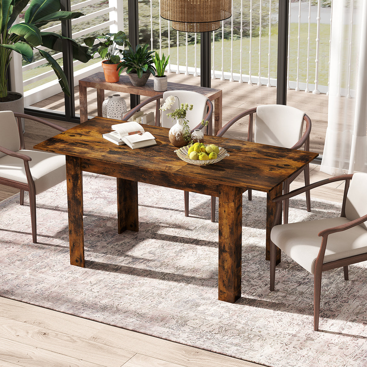 The dining table placed on a patterned rug in a sunlit room with four chairs around it
