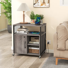The file cabinet used as a bedside table with a lamp and phone charger on top
