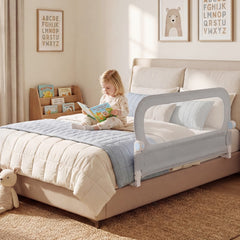 The bed rail in a child's bedroom with a girl reading on the bed