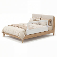 The bed rail fitted to a wooden bed frame with soft toys resting on the mattress