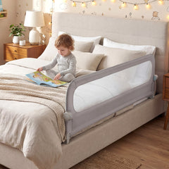 The bed rail in use on a bed with a toddler sitting up and reading a book
