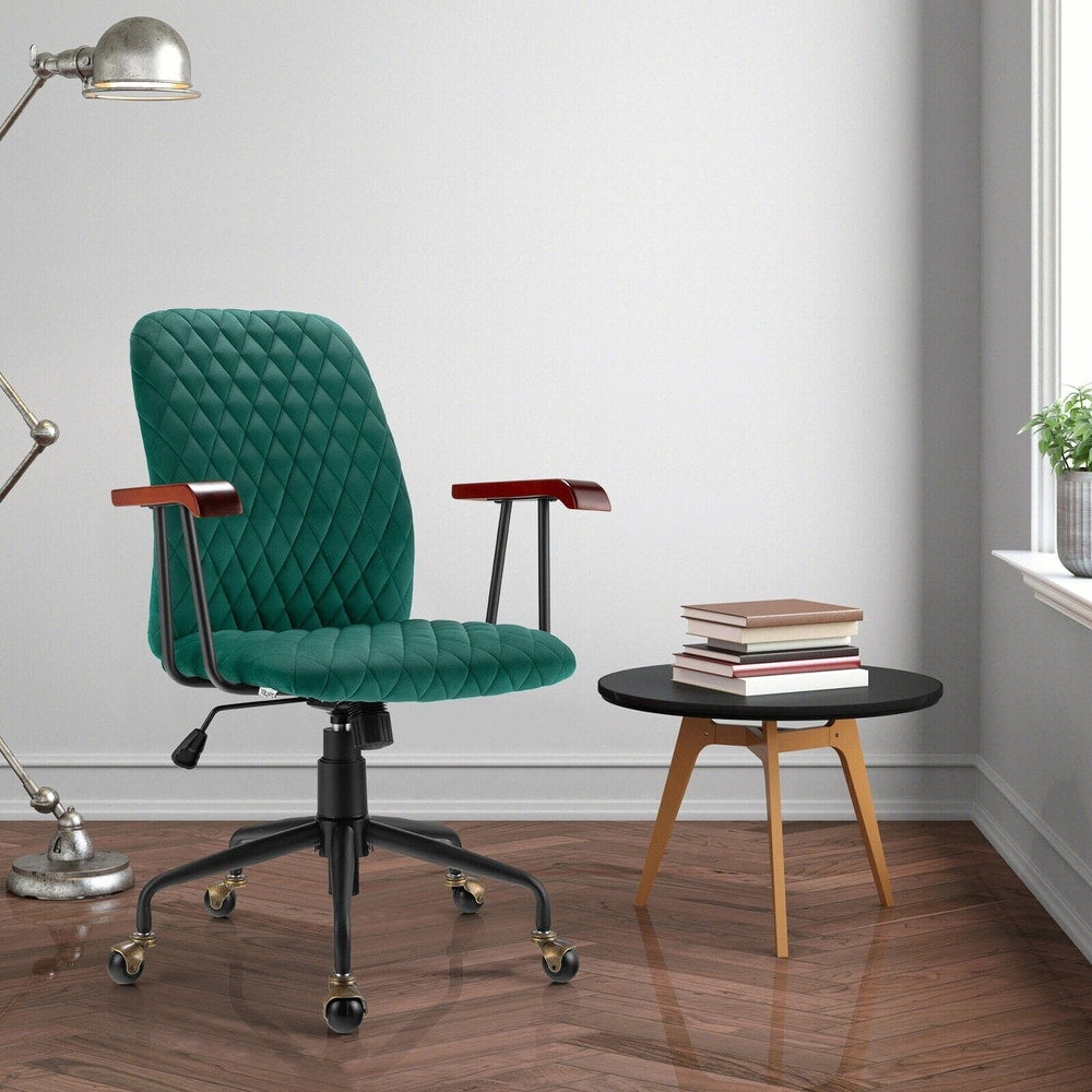 The green velvet office chair in a living room with a side table and lamp