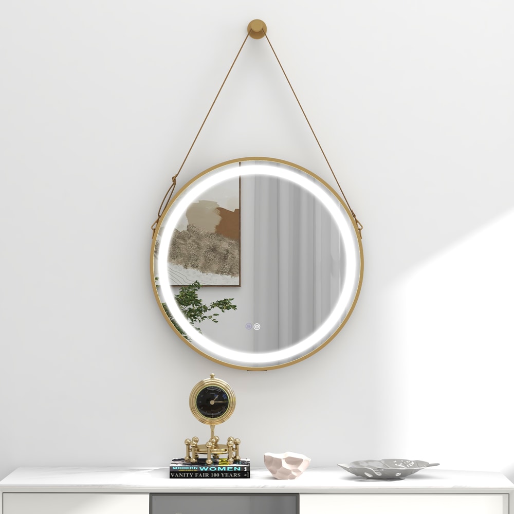The round bathroom mirror with LED light and leather strap, shown on a wall above a cabinet