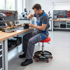 Man sitting on the red mechanic stool with storage tray at a workbench