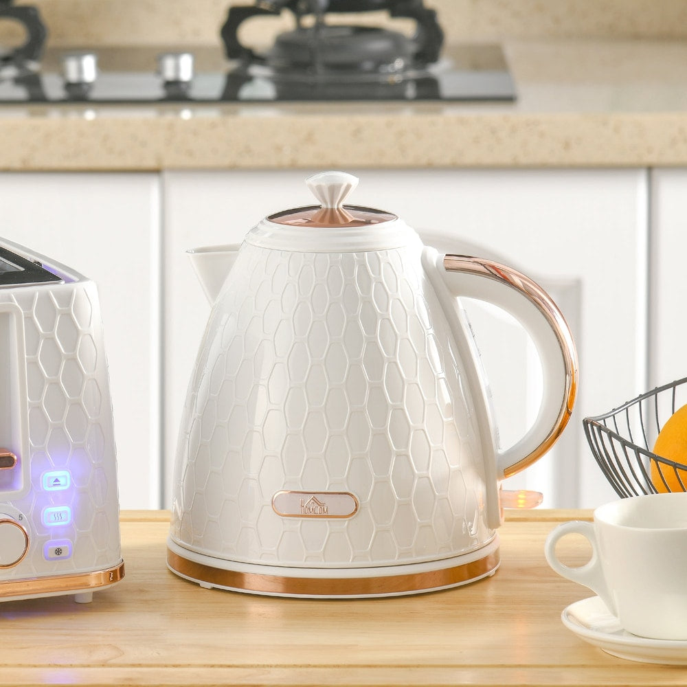 Cream honeycomb kettle with rose gold handle and trim on a kitchen counter next to a toaster and cup