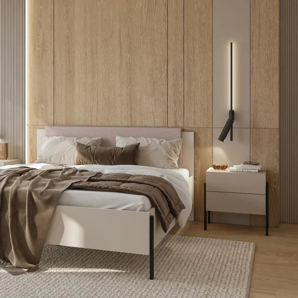 The ottoman bed viewed from the side with a bedside table and a wall light in a bedroom
