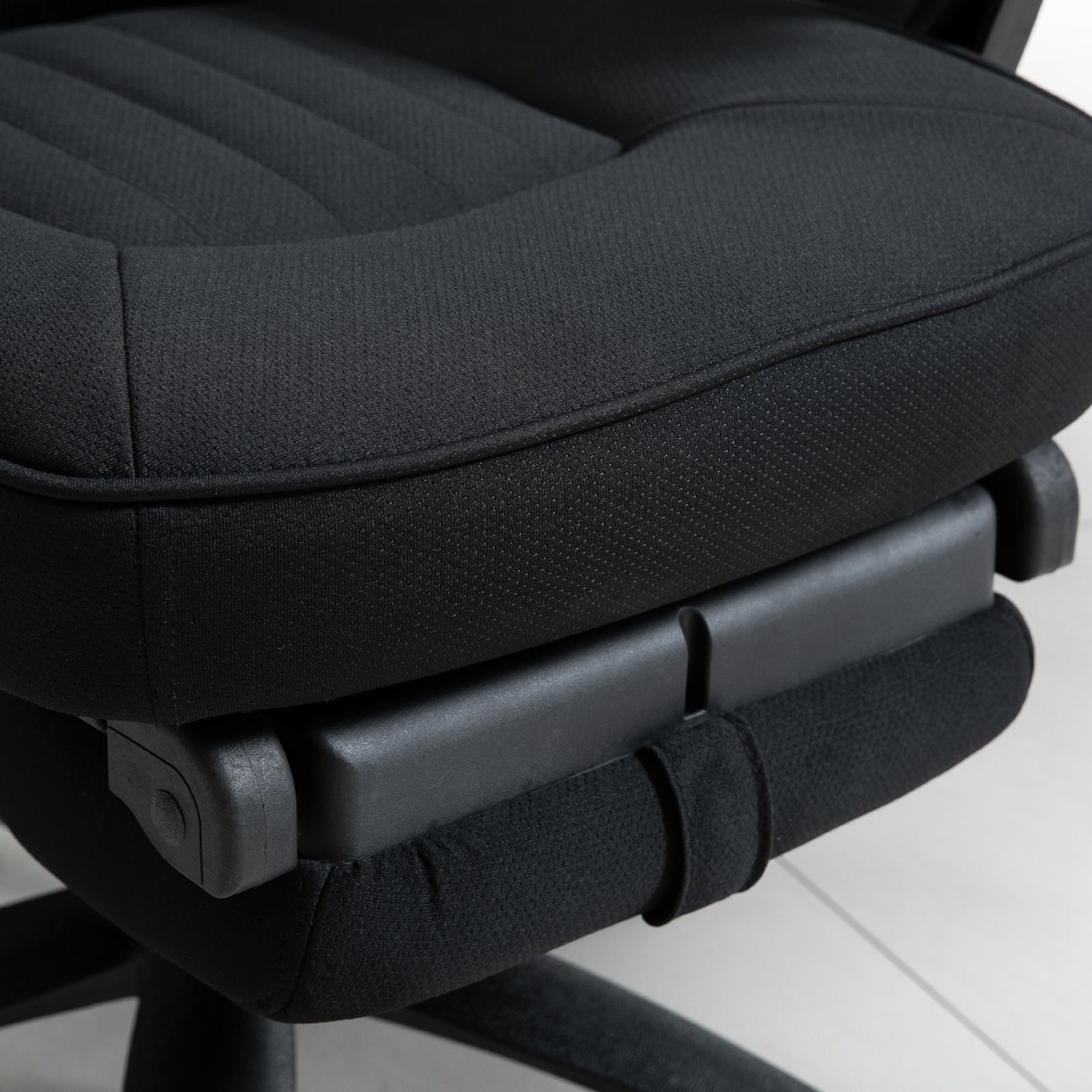 A close-up of the padded seat cushion and the retracted footrest underneath