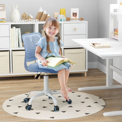The kids chair being used by a young girl sitting at a white desk reading a book in a bedroom
