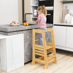 Toddler using the kitchen step stool at a counter