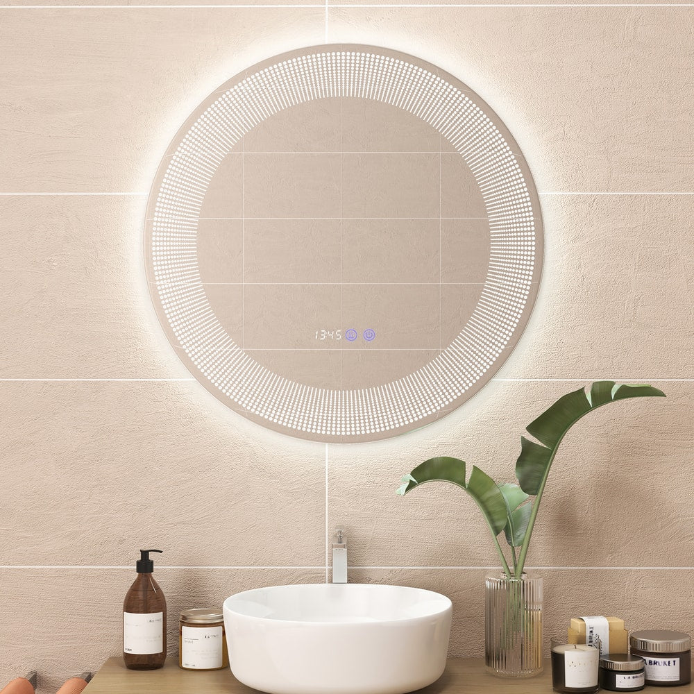 The round mirror mounted on a tiled bathroom wall above a white basin with decorative items