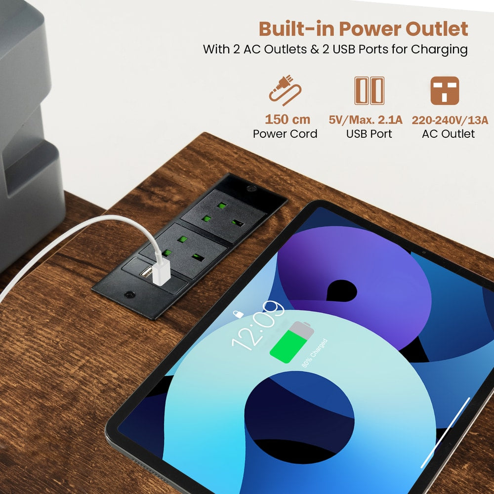 The office desk surface featuring a built-in power outlet with charging ports for devices
