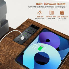 The office desk surface featuring a built-in power outlet with charging ports for devices