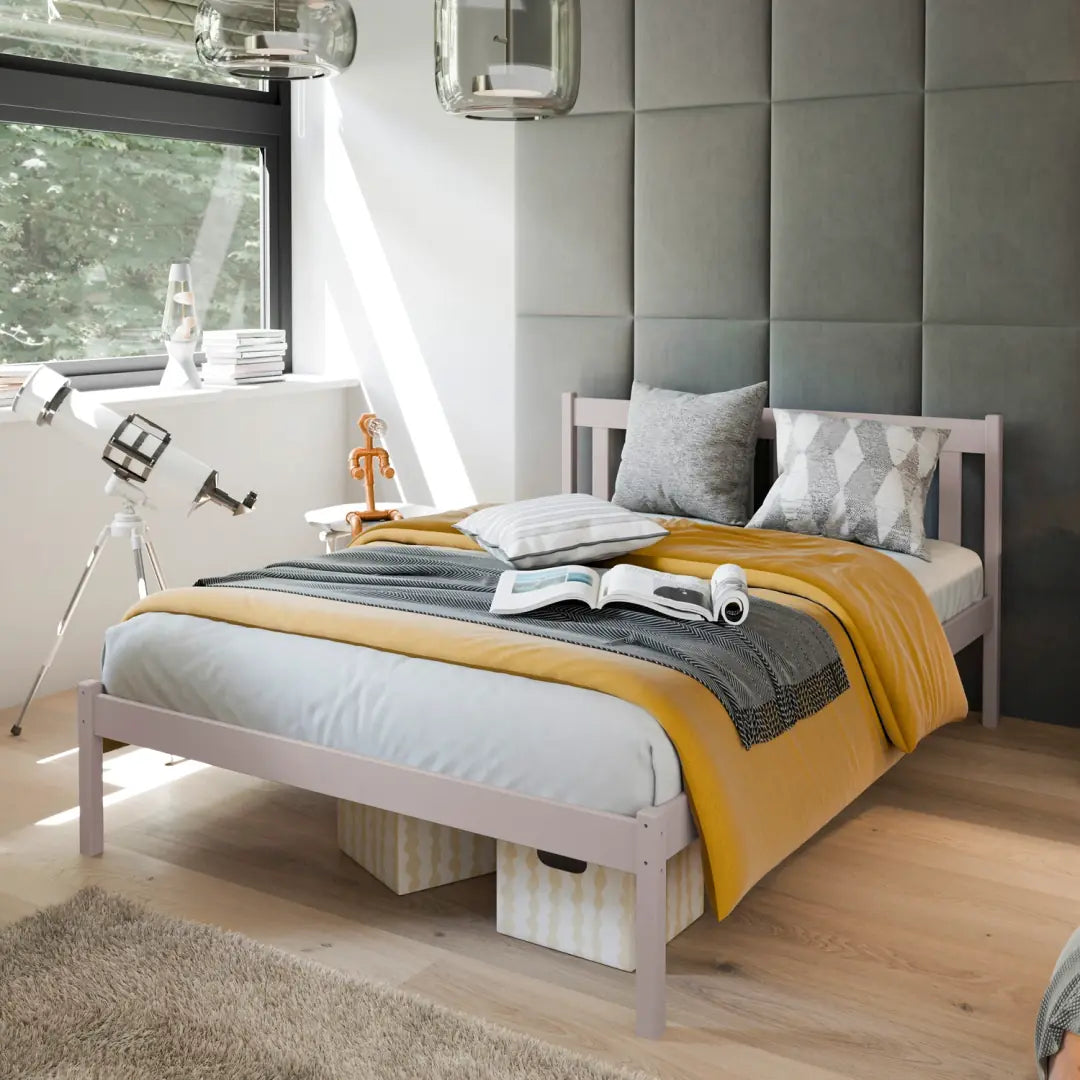 The wooden bed frame in a pale lilac colour, set up in a child's bedroom