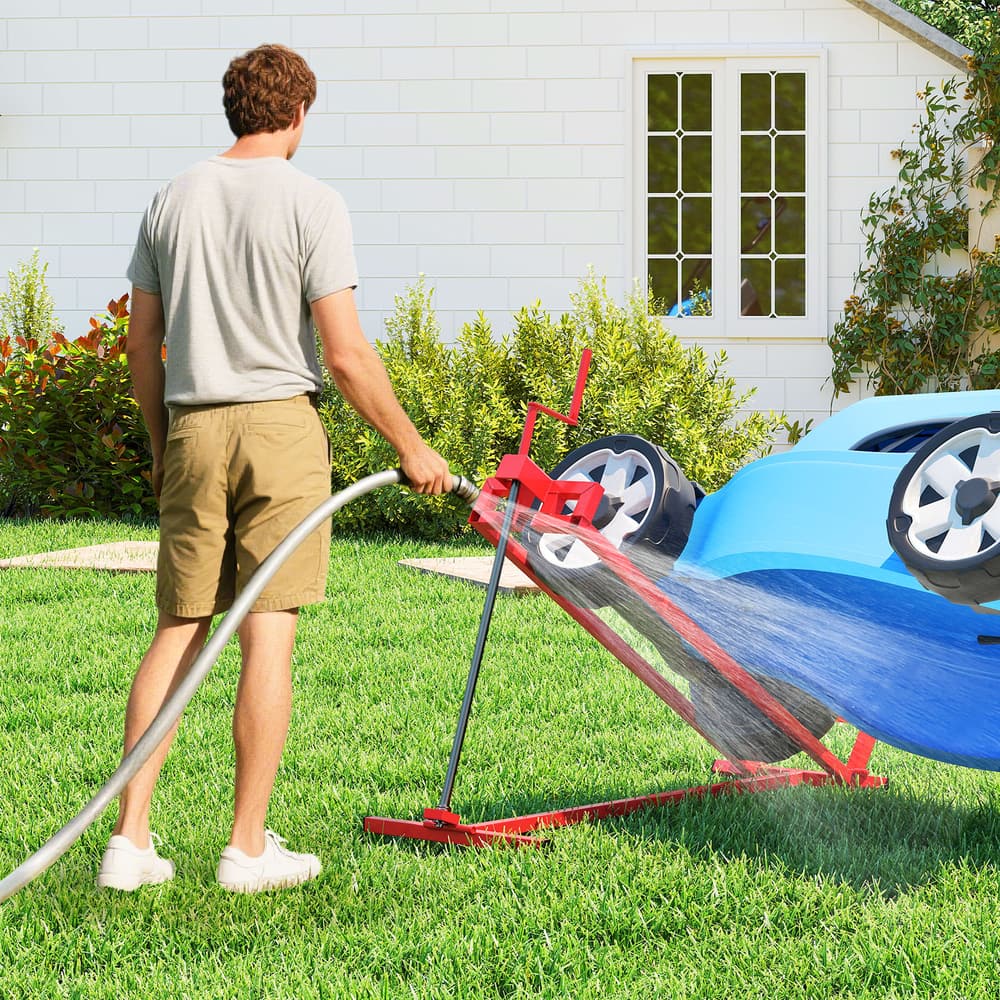 The garden tool holding a mower at an angle while a man cleans the underside with a water hose