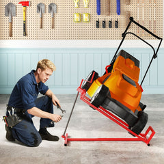 The metal lift supporting a mower in a workshop while a mechanic works on the blades