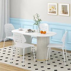 Four white metal dining chairs around an oval table in a dining room setting