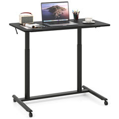 The office desk holding a laptop, a cup, and stationery items on its flat black surface