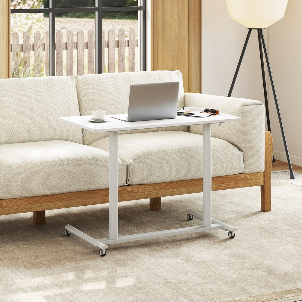 The mobile standing desk is shown next to a sofa in a living room setting