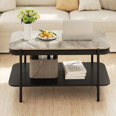 Grey marble effect coffee table with a laptop and fruit bowl on top, in a living room