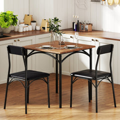 A rustic brown kitchen table with two black chairs in a kitchen setting