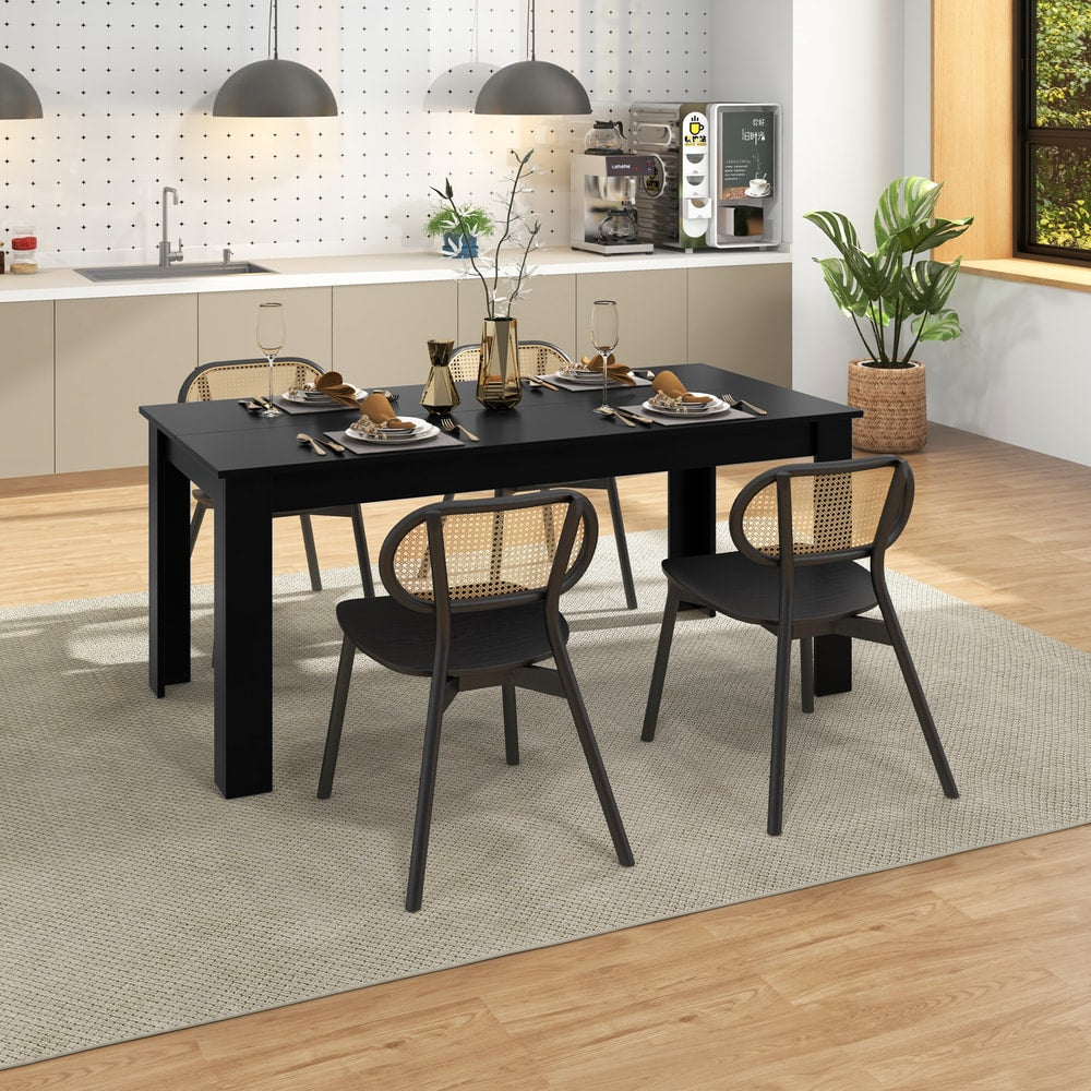 Black rectangular dining table with chairs in a breakfast nook setting