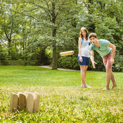 Young couple playing the wooden scatter game in a park