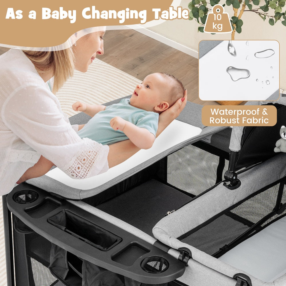 A woman changing a baby on the changing table attachment of the portable nursery center