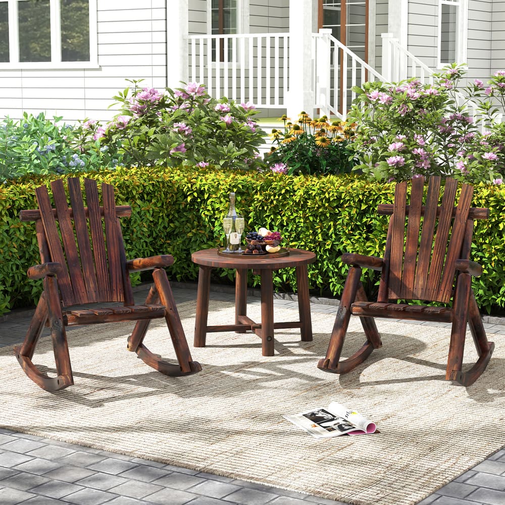 Two wooden Adirondack rocking chairs and a small table set up on a patio