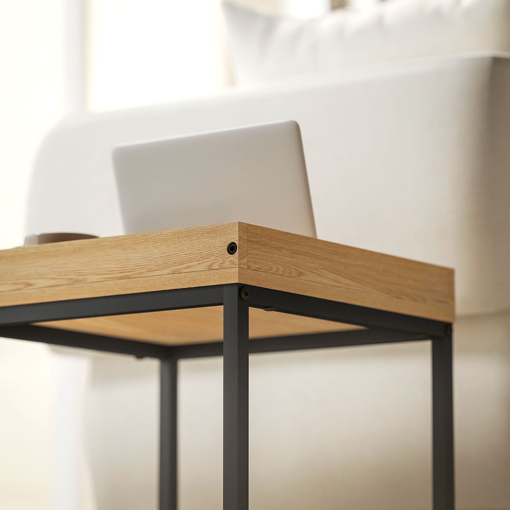 A close-up view of the wood-effect surface and black metal frame of the coffee table