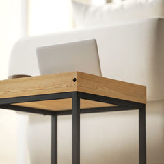 A close-up view of the wood-effect surface and black metal frame of the coffee table