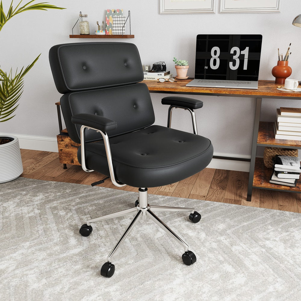 This black office chair with button tufted back is placed in a modern home office next to a desk with a laptop