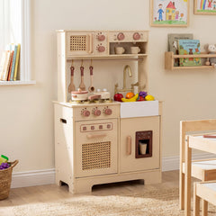 The wooden kitchen set placed against a wall in a childs bedroom with toys nearby