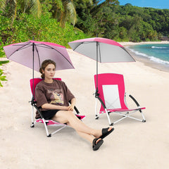 A woman sits on a pink beach chair with an adjustable parasol, another chair is behind her