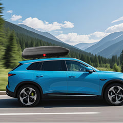 The rooftop cargo carrier mounted on a blue car driving on a road with mountains
