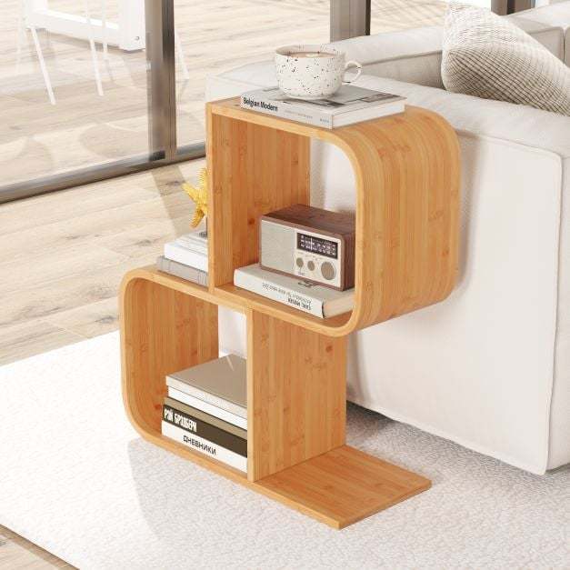 The bookcase placed next to a white sofa with books and a radio stored on the shelves