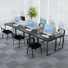 The office chairs positioned at a long desk with computers in a bright open plan office